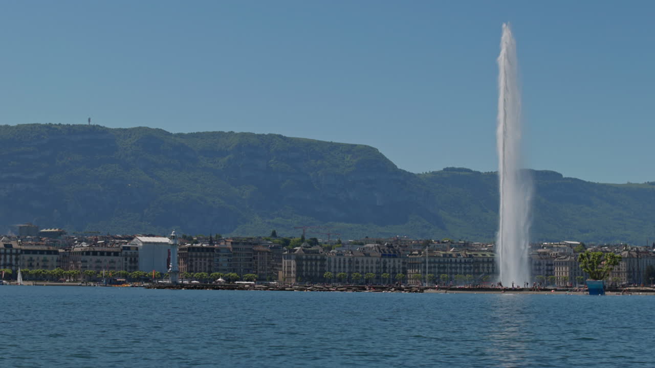 Peaceful morning in Geneva with the iconic Jet d’Eau rising from the lake, calm waters reflecting the clear sky, and the city slowly coming to life in the morning light.