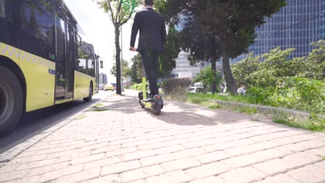 los pies de un hombre de negocios en un scooter eléctrico.