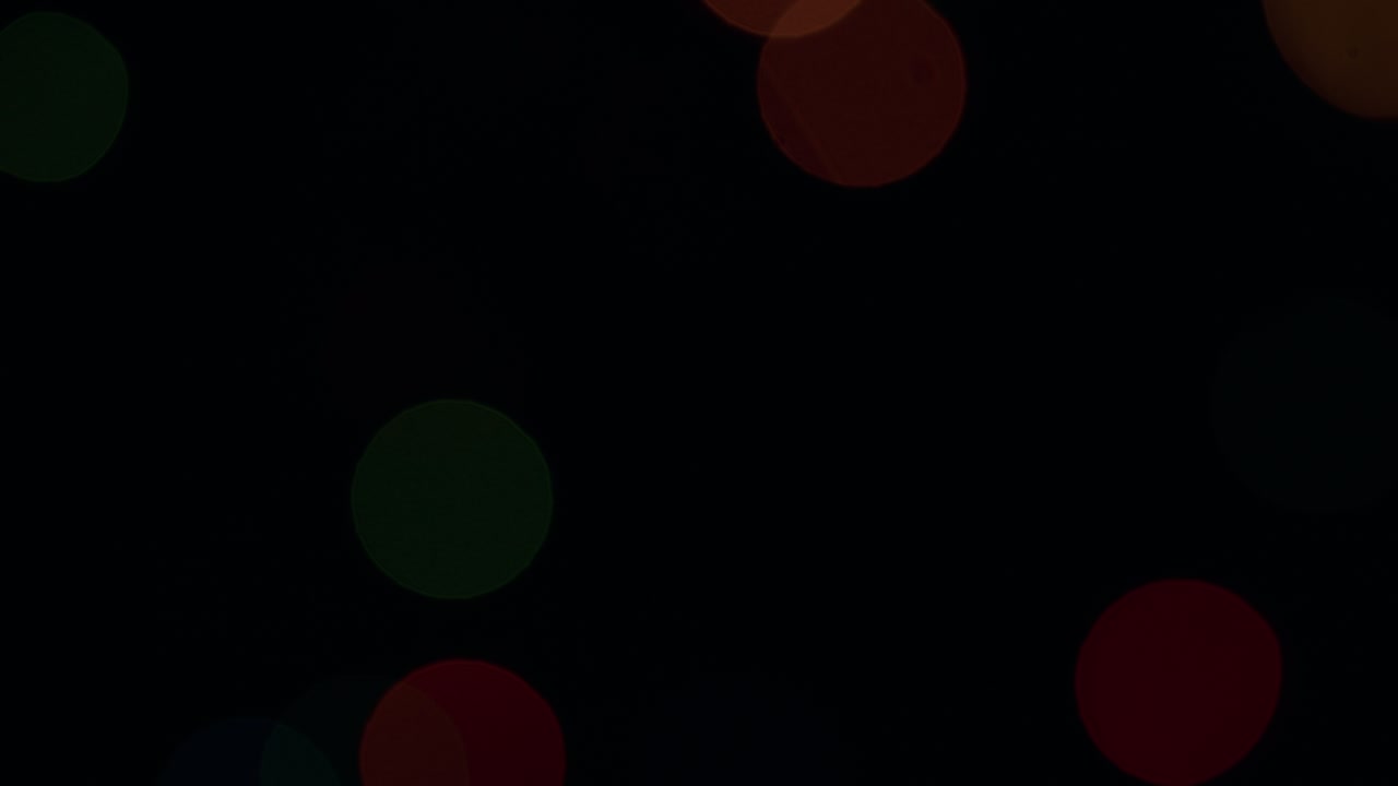 Colorful bokeh. Blink orange, red and green bokeh lights on a black background. Static