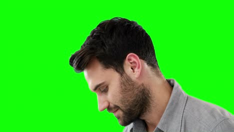 thoughtful man standing against green background