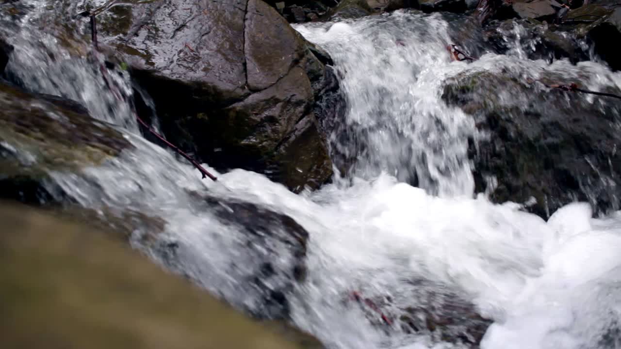 Bella cascata di montagna. Il ruscello scorre tra le pietre.