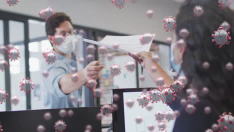 animación de células de covid-19 flotando sobre hombre y mujer con máscaras faciales, trabajando en la oficina