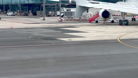 Luggage-carts-among-parked-planes,-airport-equipment-at-Madrid-Barajas-Airport-in-Spain