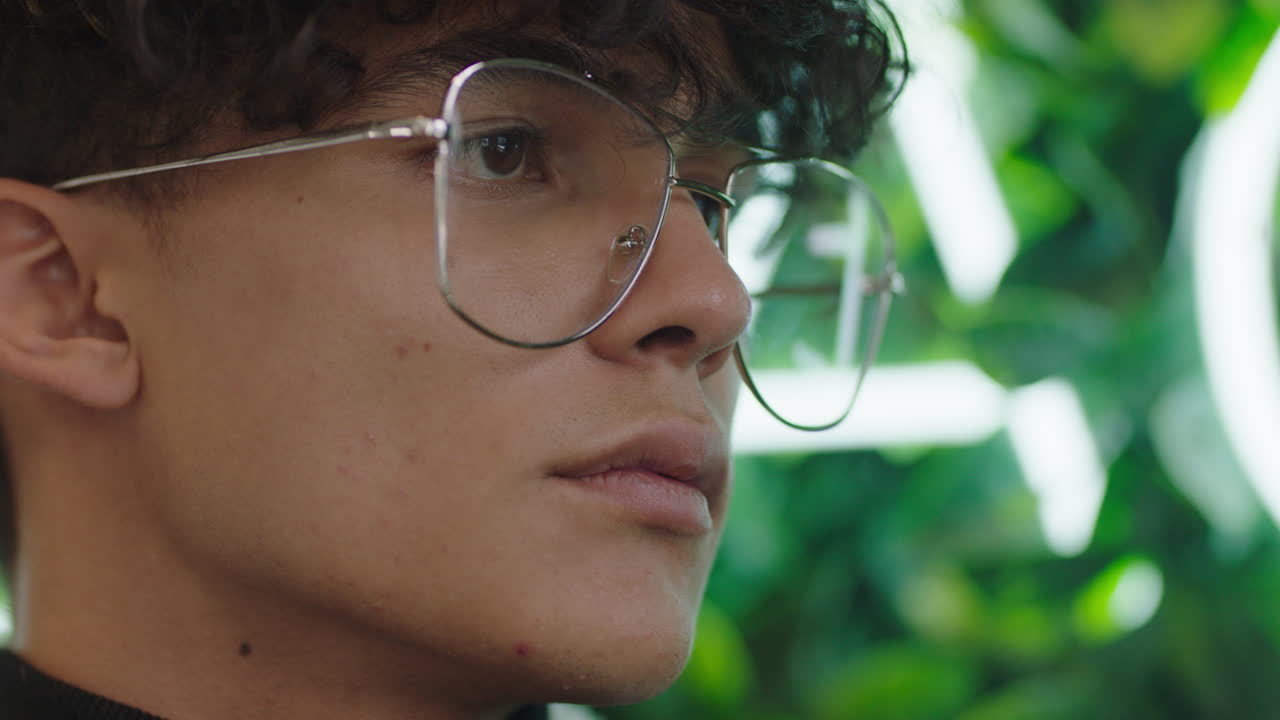 retrato de cerca de un joven atractivo estudiante con una expresión seria adolescente de la generación del milenio con gafas elegantes y de moda