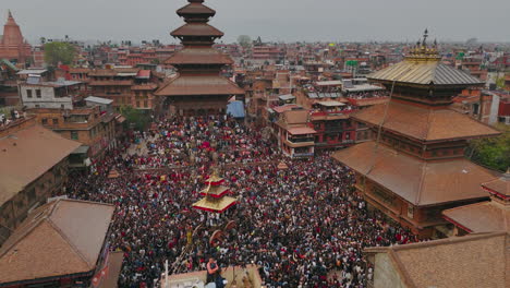 aerial view of the 5-story nyatapole temple amidst a huge crowd pulling a chariot, showing unity and prosperity of newari traditions in bhaktapur durbar square,rich architectures in kathmandu valley.