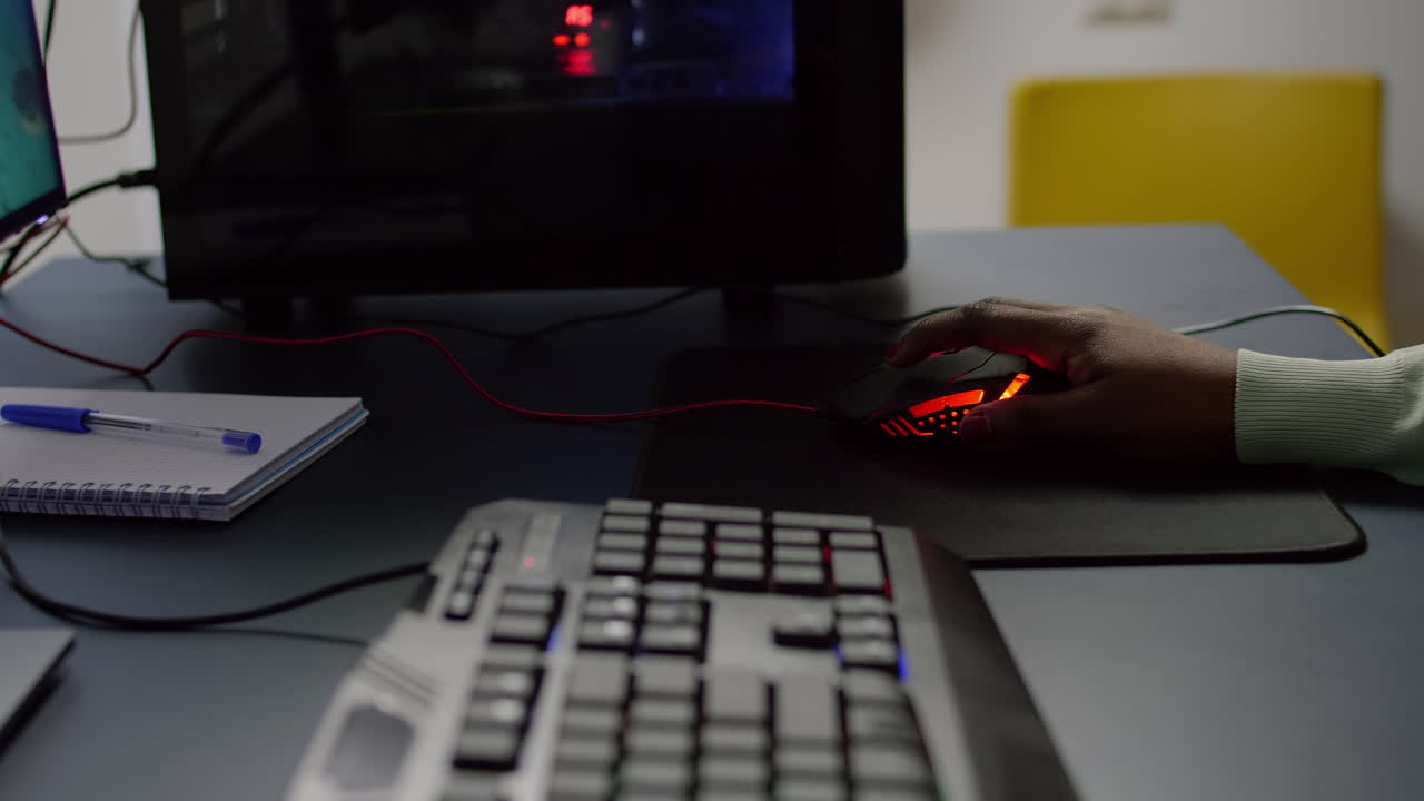 близкий снимок стримера, держащего rgb мышь, играющего в космическую шутерскую видеоигру.