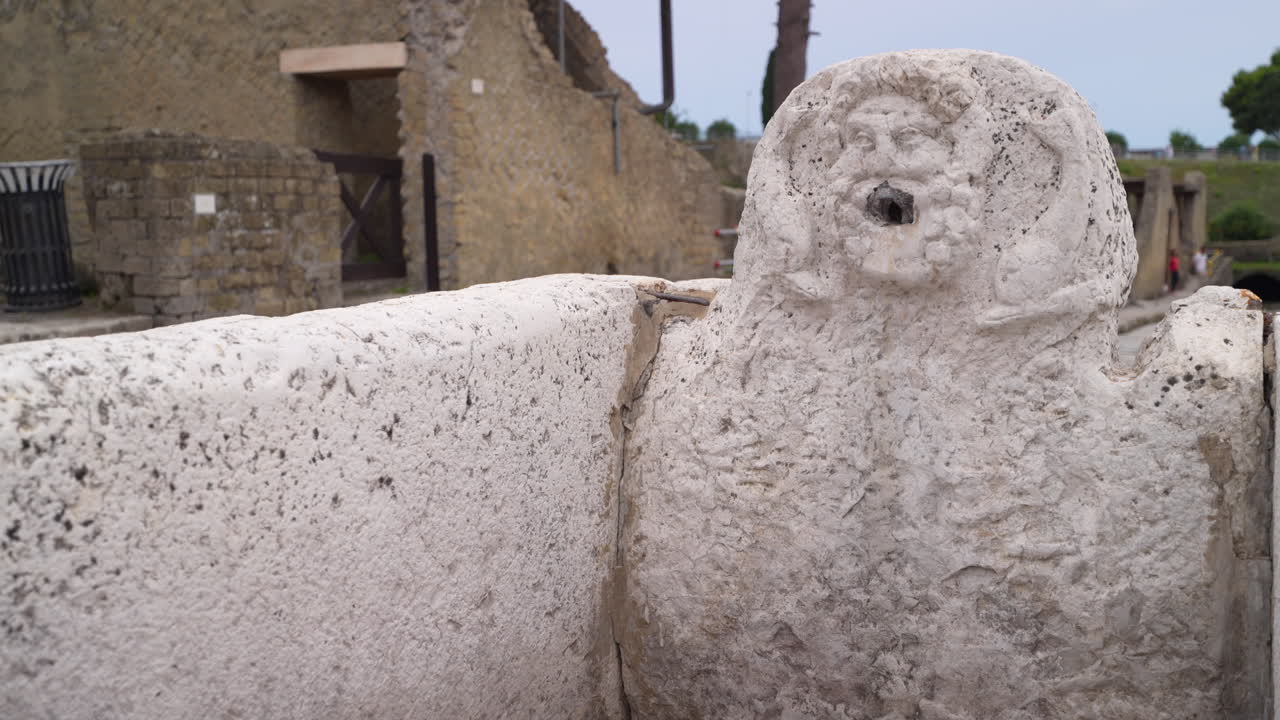 Ancient Stone Fountain with Carved Face at an Archaeological Site
