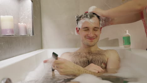 hombre tomando un champú en la bañera