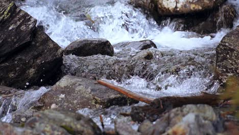 Cámara-Lenta-De-Un-Arroyo-De-Montaña-Salvaje-Que-Fluye-A-Través-De-Las-Rocas,-Primer-Plano