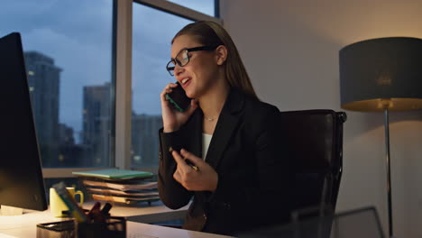 Gerente-Financiero-Hablando-Por-Teléfono-Celular-Quedándose-Hasta-Tarde-En-La-Oficina.-Mujer-Sonriente,-Trabajo