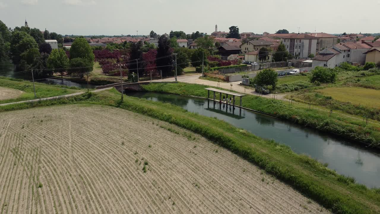 campo agrícola tierra arada con canal de irrigación río en cassolnovo italia vista aérea