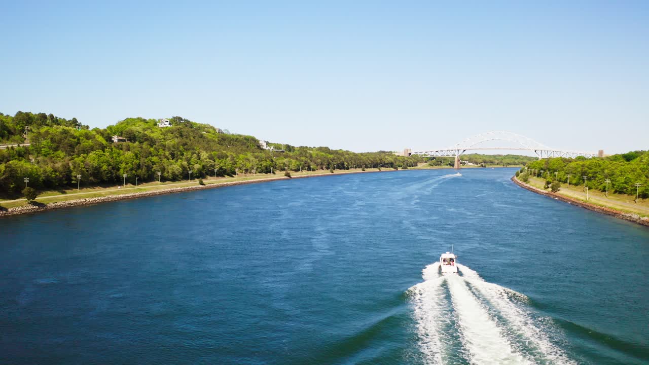 Drone segue um barco no Canal Cape Cod com a Ponte Sagamore ao longe