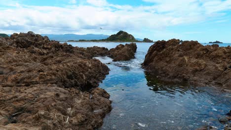 serene island vista beyond a tranquil rock pool, a picturesque scene of coastal beauty