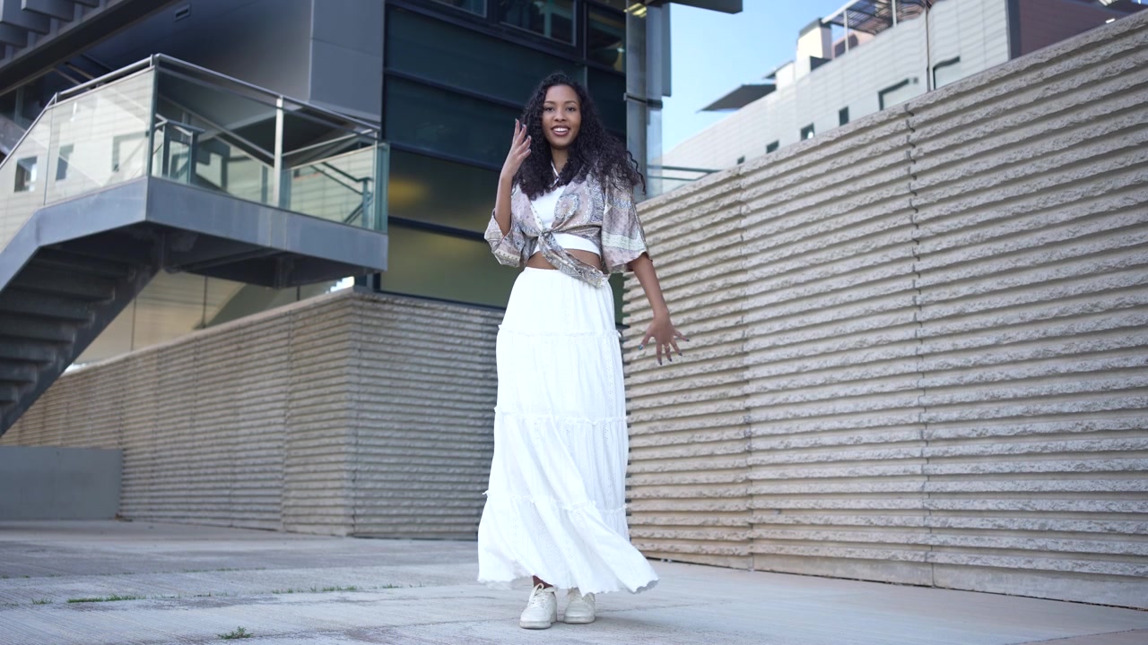 Una donna elegante in un bellissimo abito bianco che posa con grazia all'aperto nella natura.
