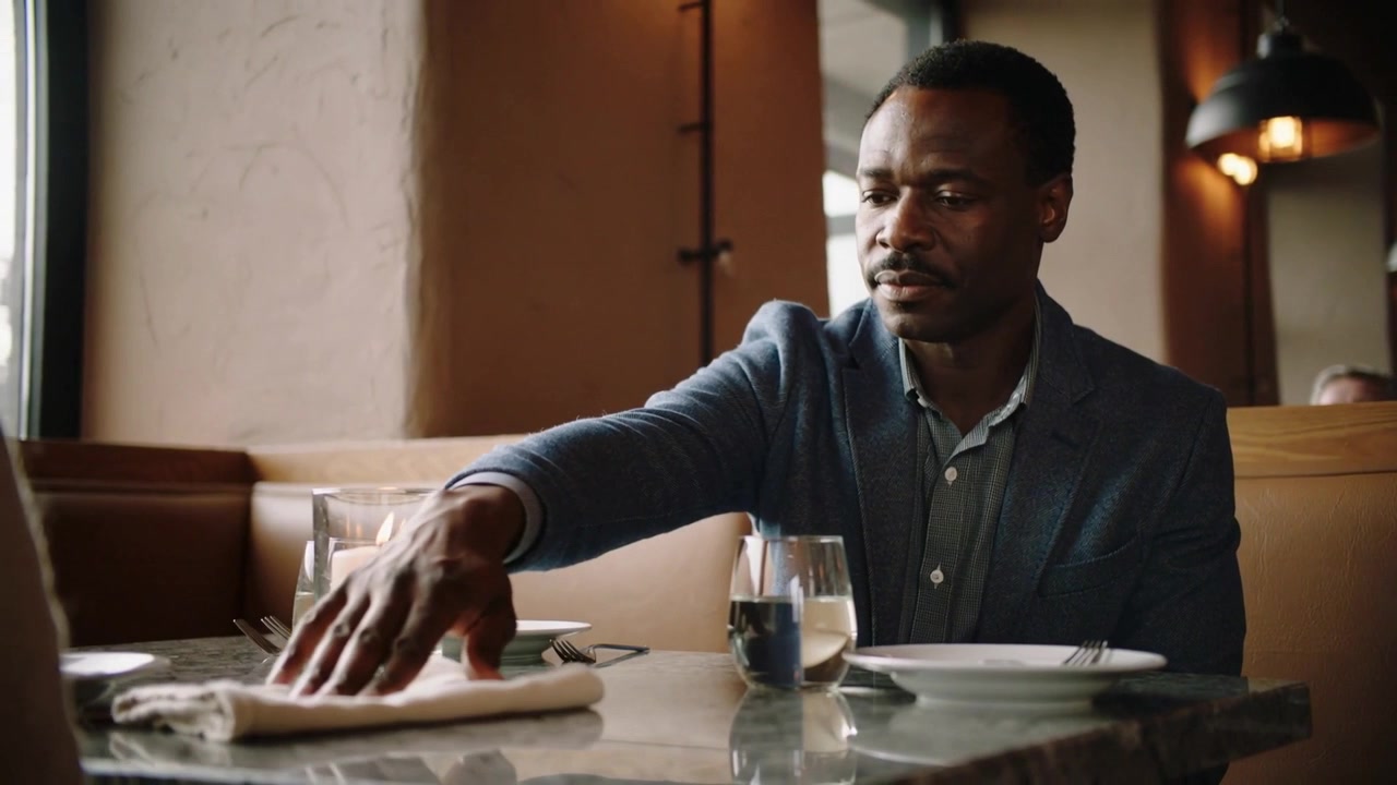 Preparing businessman in blazer adjusting cloth napkin before meal at restaurant booth with candle