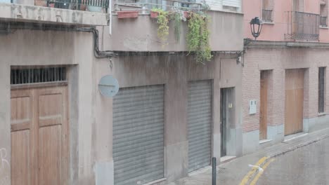 view of heavy rain on a street with houses