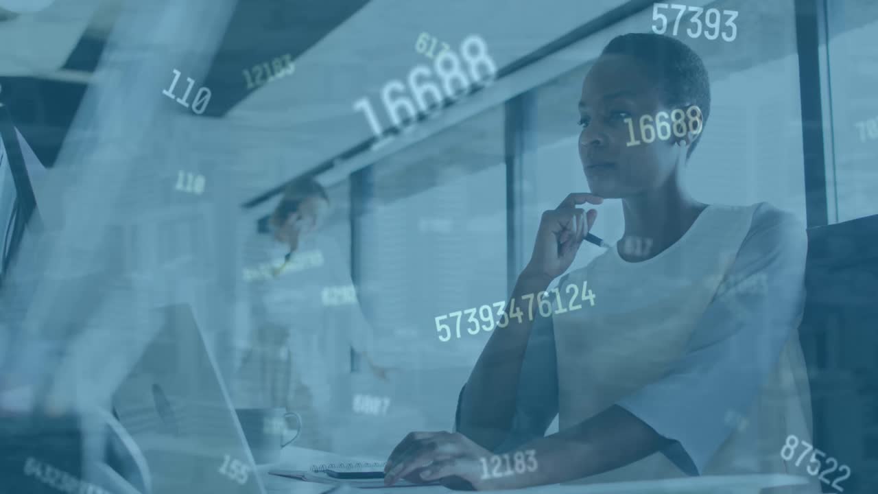 Animation of numbers changing over afrcan american woman with computer in office