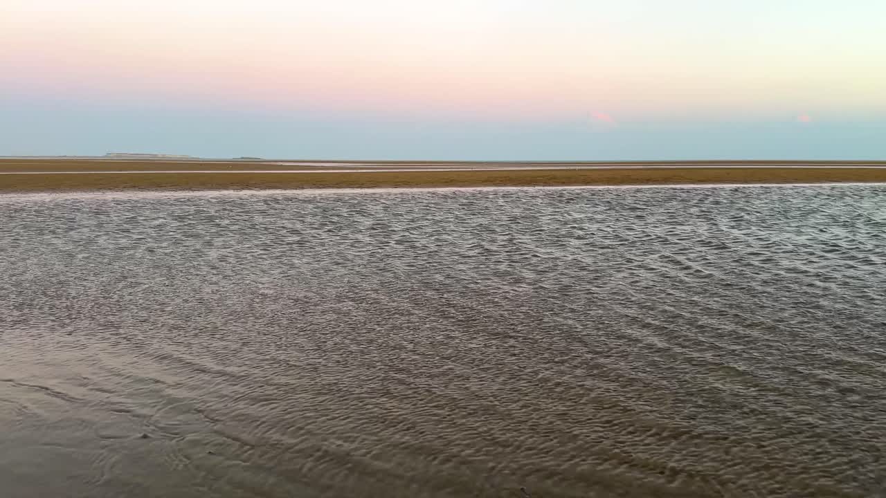 vista aérea amplia de volar sobre el mar en la playa de arena en el golfo arábigo naturaleza maravillosa paisajístico hermoso horizonte en la puesta de sol colorido crepúsculo en el horizonte rosa color púrpura cinturón de venus sombra de la tierra en el océano