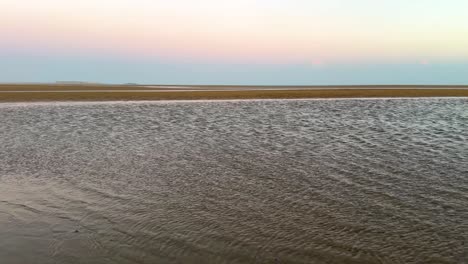 aerial-wide-view-of-fly-over-the-sea-in-sand-beach-in-Arabian-gulf-wonderful-nature-scenic-beautiful-skyline-in-sunset-colorful-twilight-in-horizon-pink-purple-color-Venus-belt-earth-shadow-on-ocean