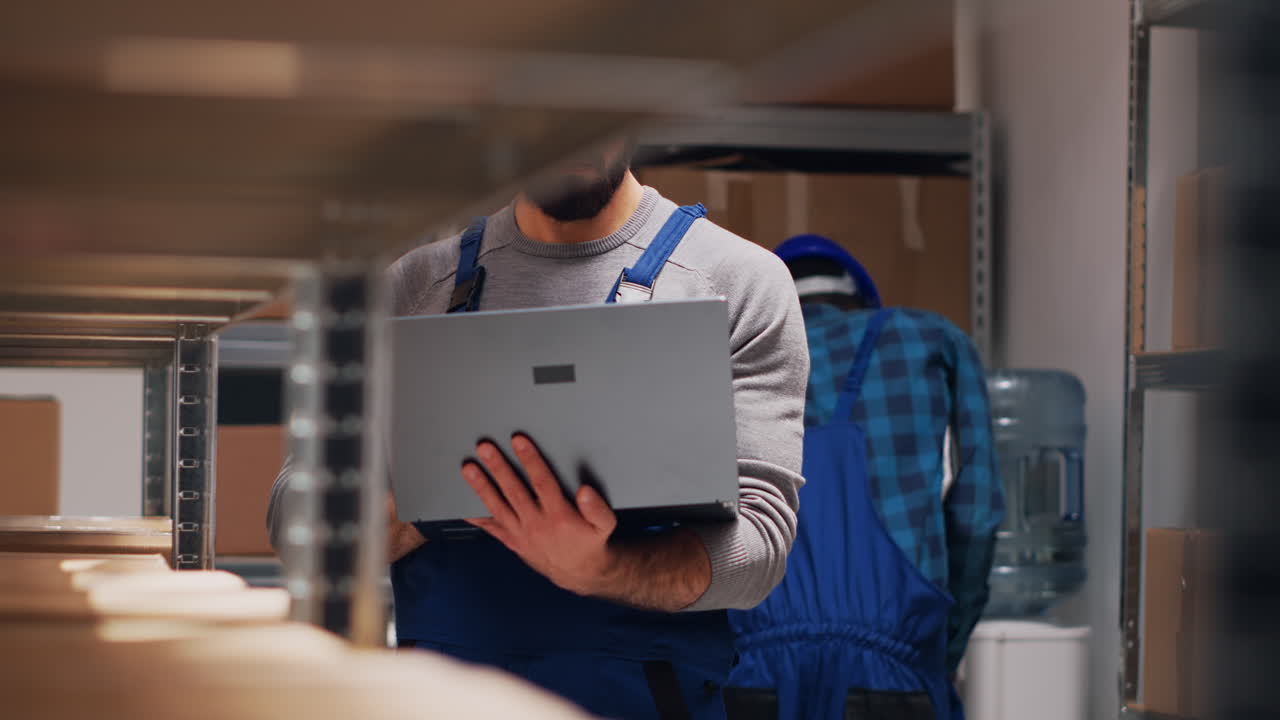 Warehouse Worker with Laptop Checking Inventory