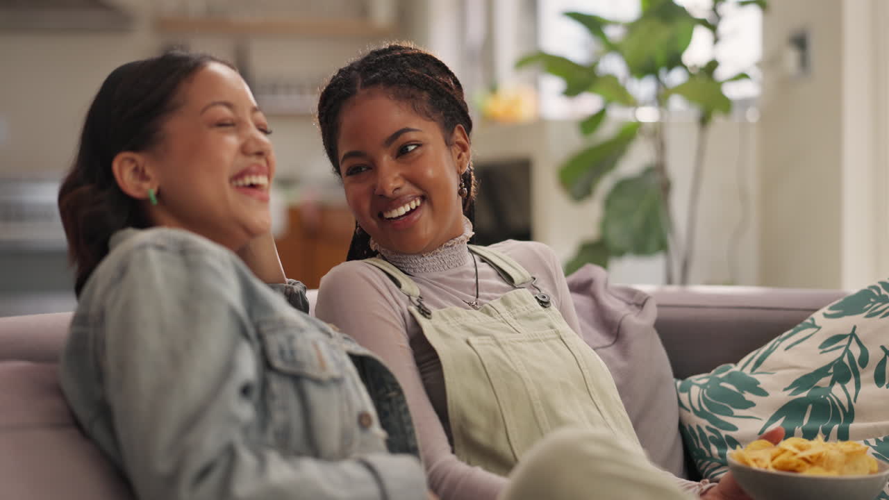Two friends laughing together on a couch