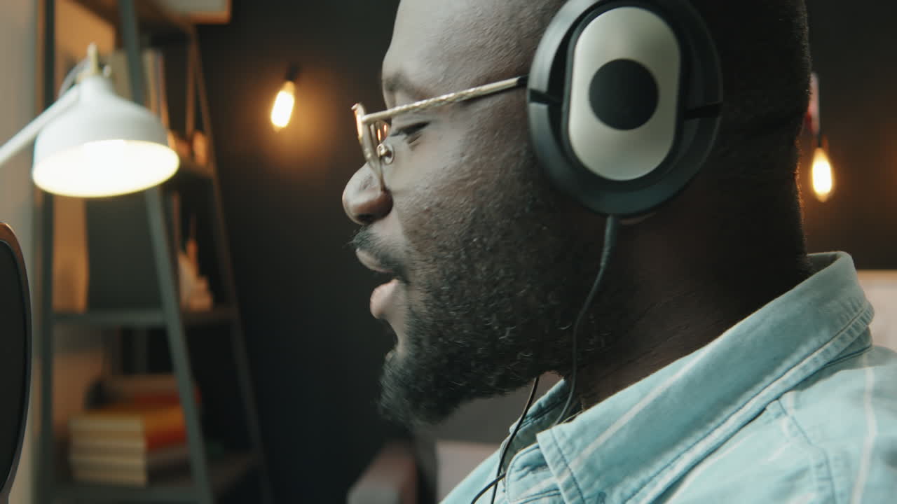 Black Man in Headphones Talking in Mic and Recording Podcast