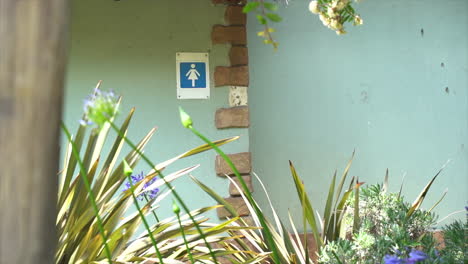 female toilet signage on wall in public space, slow panning shot left to right