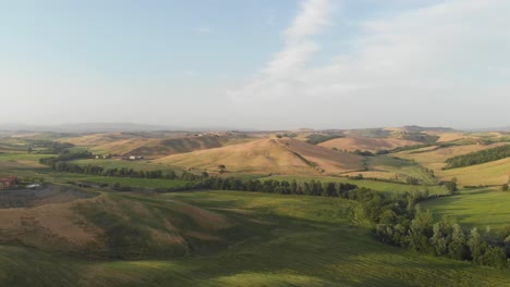 Drone-Idílico-Campo-En-Toscana,-Campos-Dorados-Y-Prados-Verdes-En-Verano