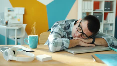 seamless loop of businessman sleeping in office on laptop while steam going up from coffee cup