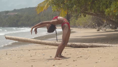 Chica-Contorsionista-En-Bikini-Se-Dobla-En-Una-Posición-De-Contorsión-En-La-Arena-De-Una-Increíble-Ubicación-En-La-Playa