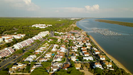 aerial shot of beautiful small harbor city of el romipdo with hotel,residential area,sandy beach and port with boats - spain,europe