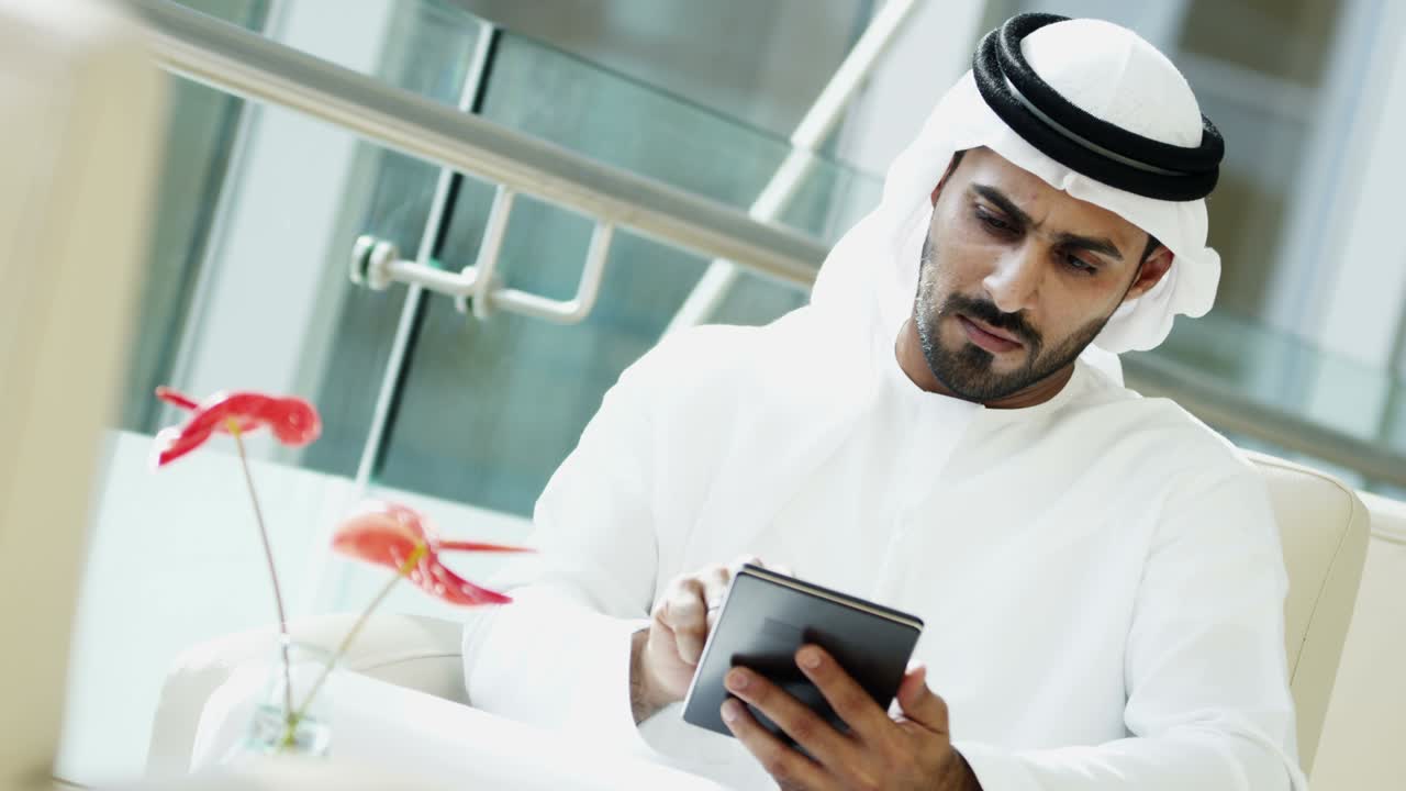 empresario árabe con vestido nacional usando tecnología de tableta
