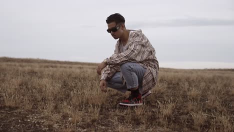 Low angle cinematic shot of young Asian male model wearing loose casual clothes and goggles, posing outdoors