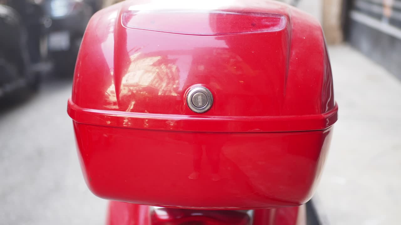 caja de tapa roja en un scooter