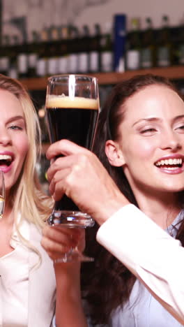 smiling friends toasting together with wine and beer