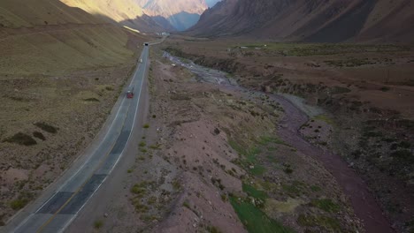 Aerial-view-of-the-road-with-vehicles-passing-by-between-the-mountains-along-the-river