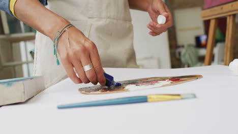 Artist-prepares-palette-in-a-bright-studio