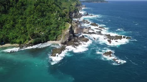 Hermosa-Toma-Aérea-De-Drones-Del-Borde-De-Una-Costa-Montañosa-Donde-El-Océano-Golpea-Las-Rocas-Espumosas-Blancas