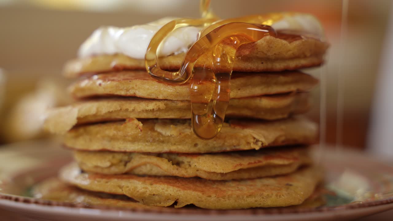 verter miel en panqueques apilados en pila, cámara lenta en primer plano extremo