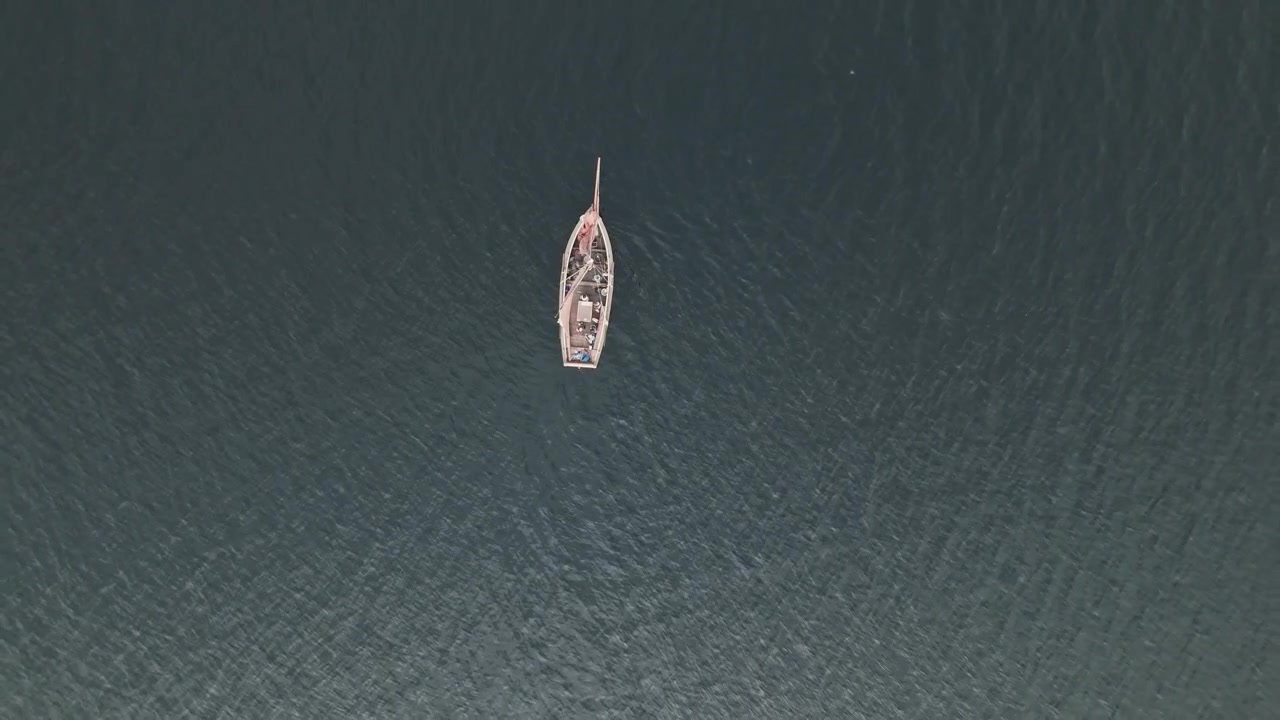 Barca a vela solitaria su acque profonde, vista aerea dall'alto in ascesa