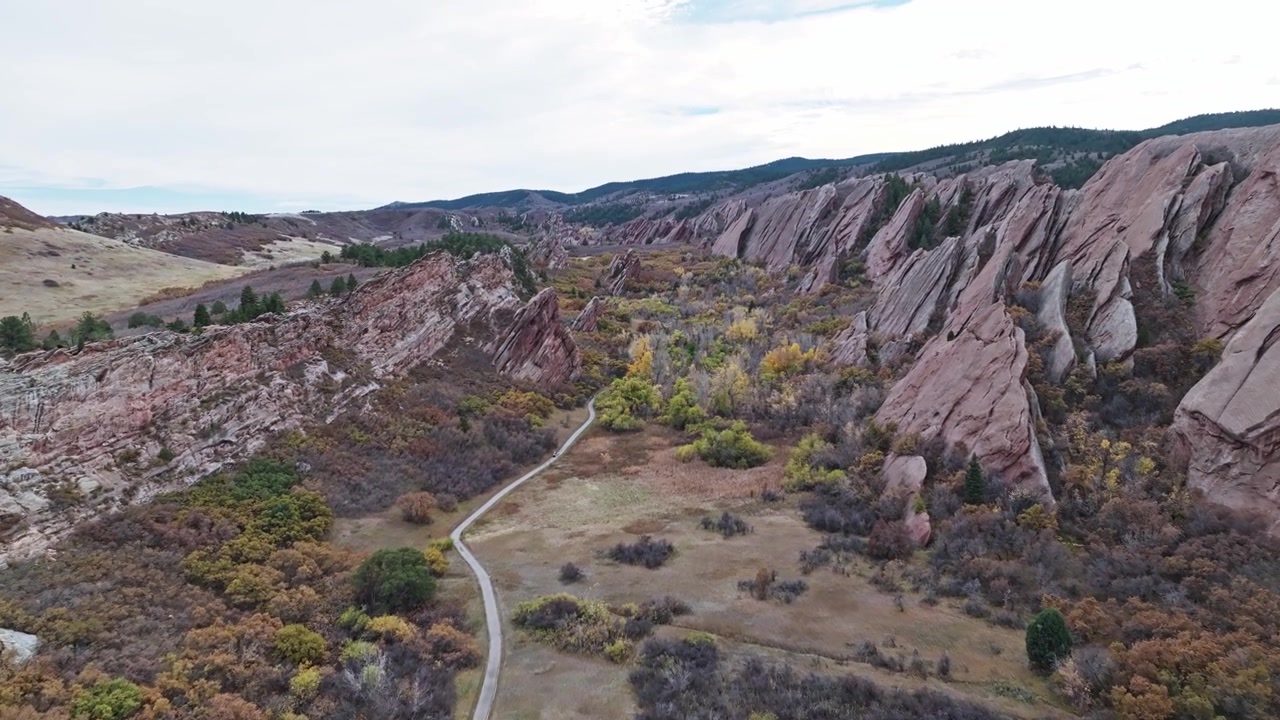 Panoramica aerea mozzafiato di un bellissimo sentiero attraverso un campo da golf incorniciato da spettacolari scogliere rocciose e vegetazione lussureggiante