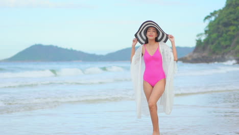 Slow-motion-view-of-woman-walking-on-beach-in-shallow-water