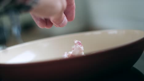 culinary elegance: slow motion close-up of hand adding pancetta, guanciale, bacon to pan for carbonara