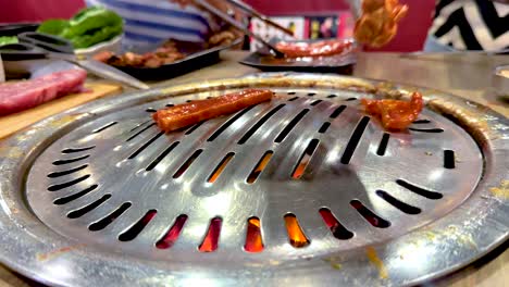 close-up of meat grilling on a korean bbq in bangkok. vibrant colors, dynamic angles, and lively atmosphere captured