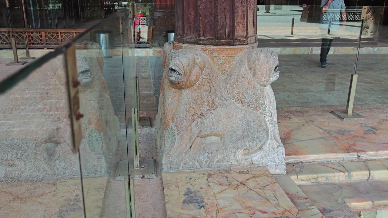 Ancienne sculpture de lion en pierre sur un site historique.