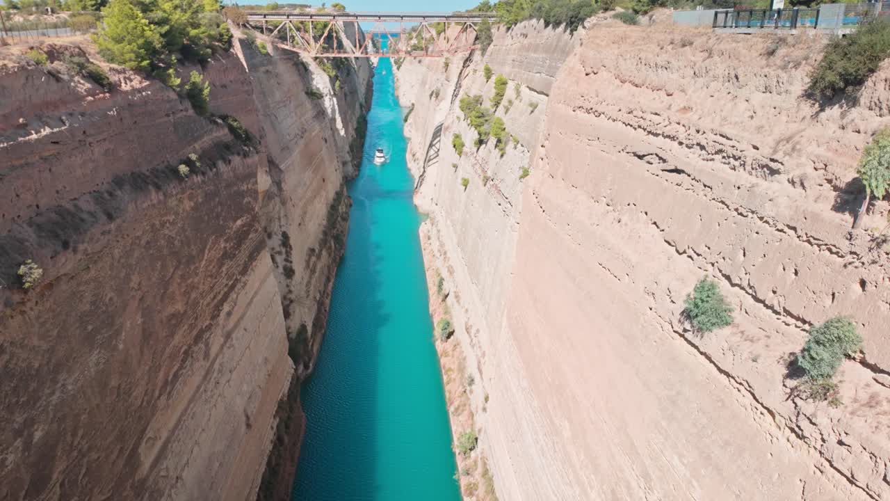 Boat navigates Corinth canal channel to Saronic Gulf Aegean Sea.