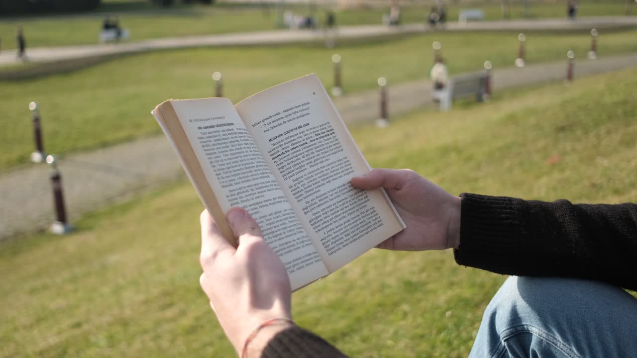 Tenere un libro al parco