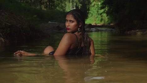 a young girl wearing a black dress admires the river.