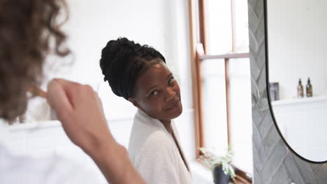 young diverse couple brushes their teeth at home