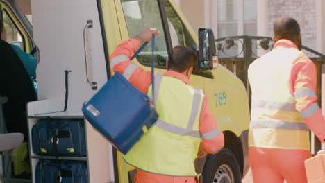 two medical assistances getting out the ambulance and running to the house where the sick people are